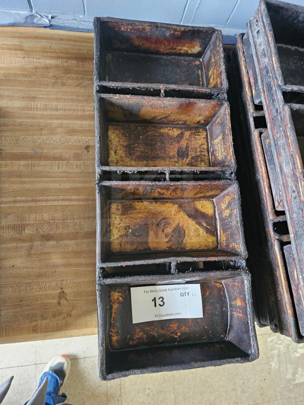 Vintage baking pan with six rectangular cavities, showing signs of wear and patina. Auction label indicates quantity: 4.