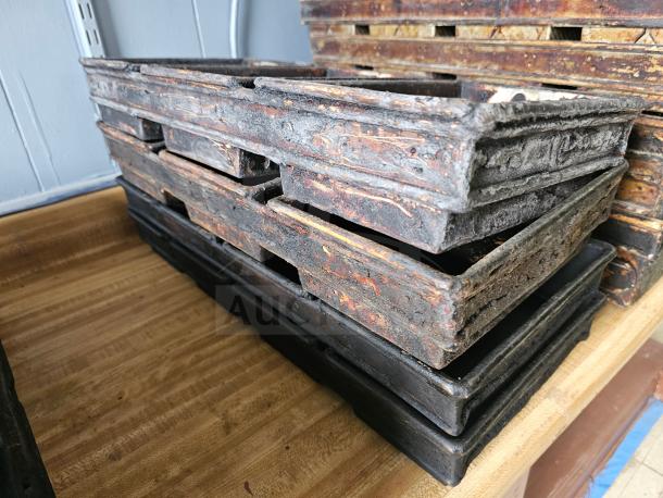 Rustic cast iron baking pan set, stacked, with weathered patina. Ideal for vintage decor or culinary use.