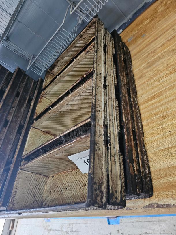 Aged metal baking pan with ribbed texture, showing signs of wear. Paper tag inside indicates auction item number 10.