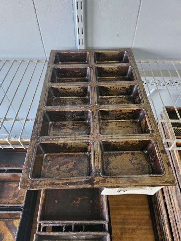 Vintage metal baking pan with twelve slots, well-worn patina, rectangular shape, ideal for crafting or kitchen use.