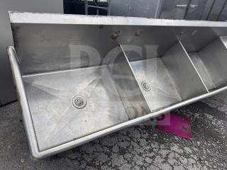 Stainless steel 3-bay sink with "Wash," "Rinse," "Sanitize" labels, used condition, visible wear.