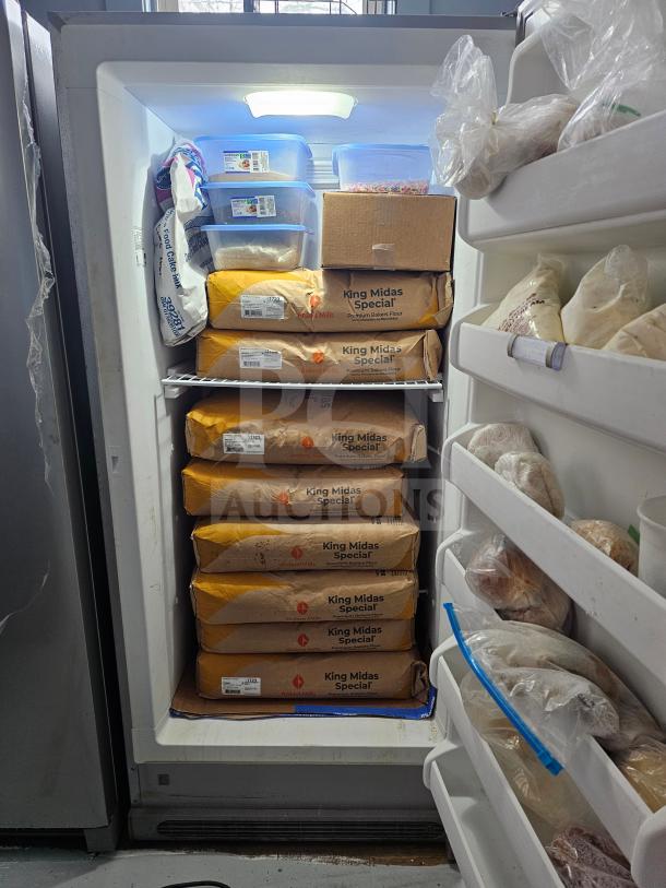 FRIGIDAIRE single door freezer, no handle, stocked with flour and storage containers, interior light, fair condition.