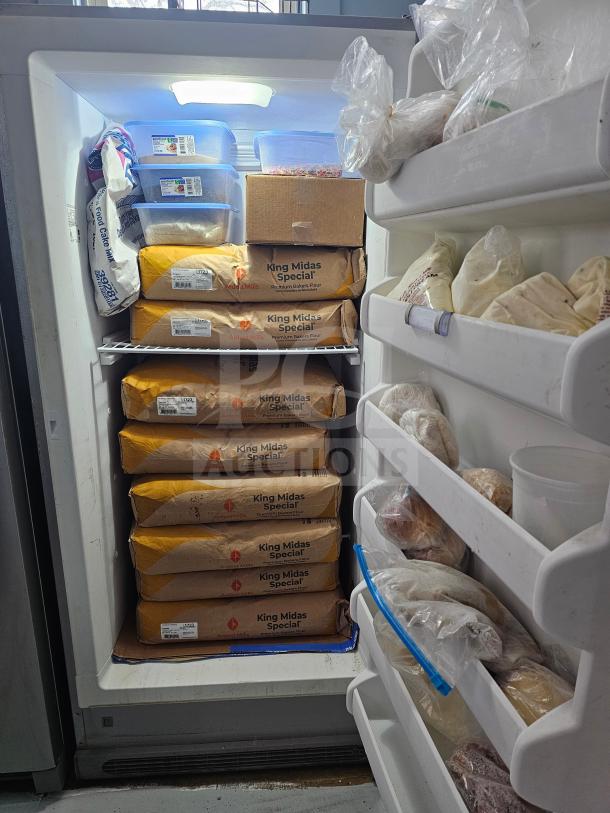 FRIGIDAIRE single door freezer, missing handle, stocked with flour and food items, interior shelves visible.