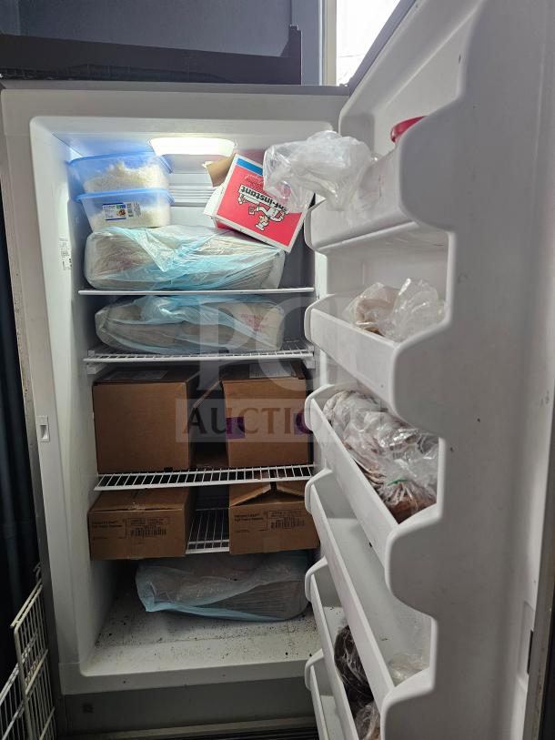 FRIGIDAIRE single door freezer, stocked shelves, door storage, visible interior light, good condition, no visible damage.