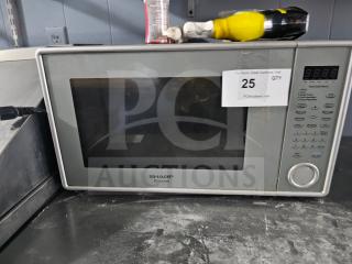 Sharp Carousel microwave, silver finish, digital display, multiple settings. Visible wear, auction tag with "25" label indicated.