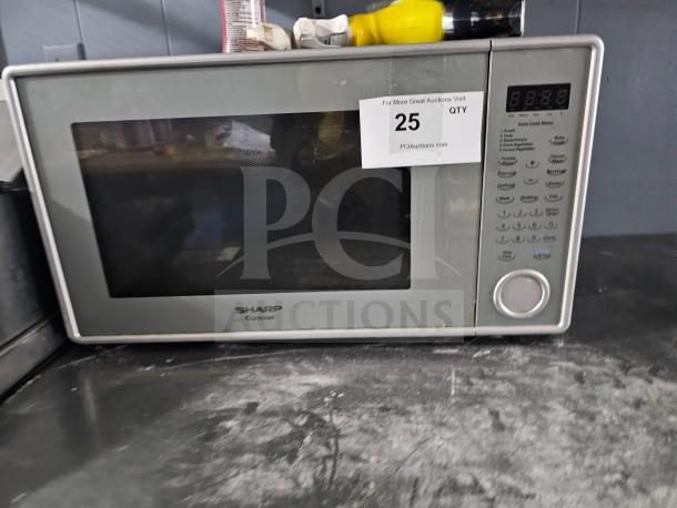 Sharp Carousel microwave with digital display and control panel. Shows signs of use. Tag indicates auction lot 25.