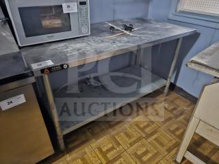 Stainless steel work table with undershelf, visible Aero and NSF labels, surface wear, ideal for kitchen use.