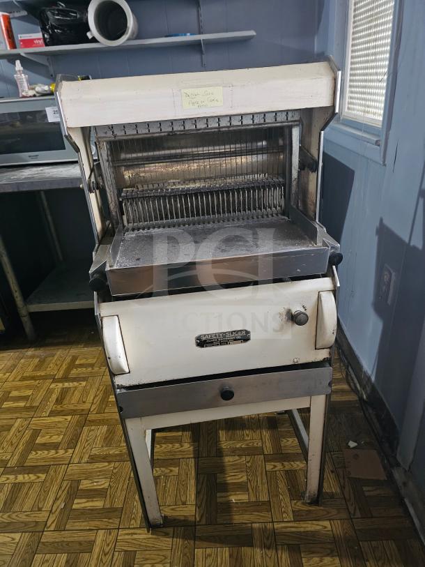 Oliver Machinery bread slicer, vintage model. Features stainless steel blades, safety panel, and instruction label. Used condition.