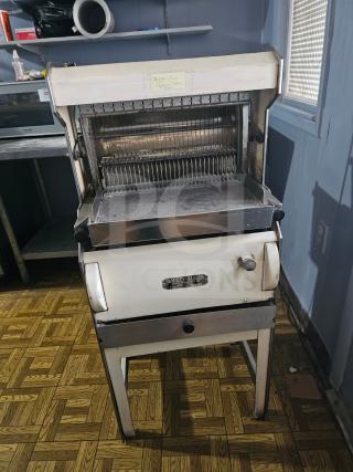 Oliver Machinery bread slicer, vintage model. Features stainless steel blades, safety panel, and instruction label. Used condition.