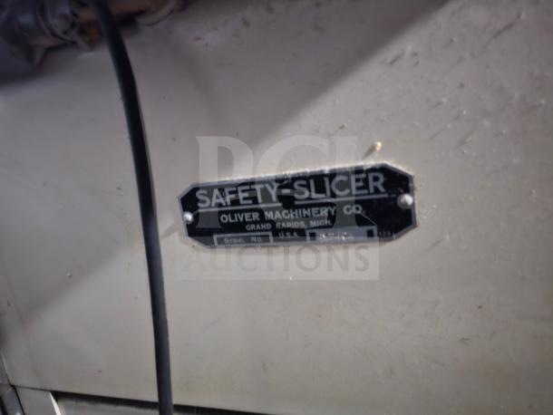 Oliver Machinery bread slicer nameplate reads "Safety Slicer, Oliver Machinery Co., Grand Rapids, Mich., USA" with serial number.