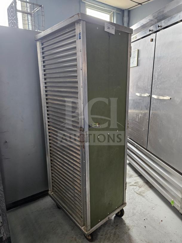 Sheet pan rack/cabinet with corrugated metal design, lockable door, and visible wear. Features label "28" on the top.