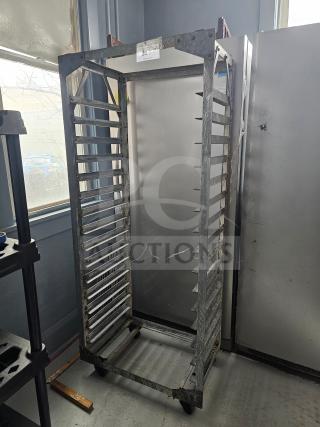 Aluminum sheet pan rack with multiple slots, on caster wheels, in used condition. Suitable for commercial kitchens.
