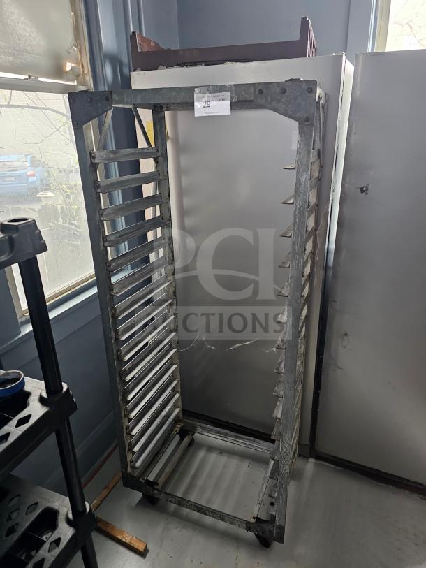 Aluminum sheet pan rack on casters, holds multiple pans, industrial use, visible label with "29" quantity tag.