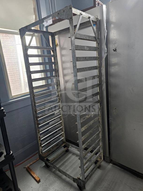 Aluminum sheet pan rack with multiple shelves, used condition, sturdy frame, on casters for mobility.
