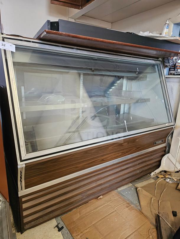 Fogel refrigerated deli display case, several signs of wear, non-functional, wood paneling, glass front, shelving inside.