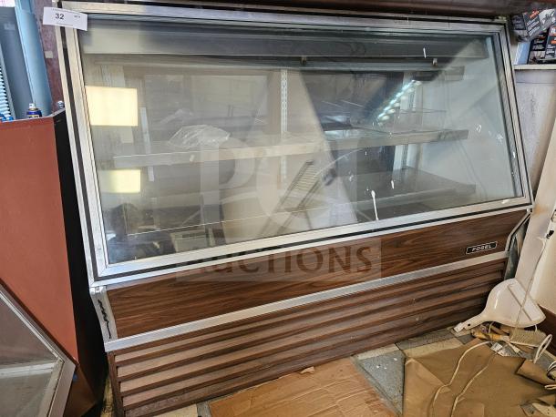 Fogel refrigerated deli display case, visible signs of wear, non-functional, wood paneling, and glass front.