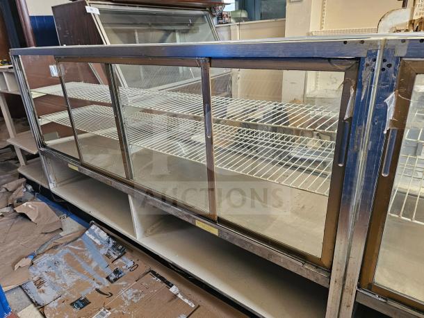 Commercial display case with glass sliding doors, metal frame, and wire shelving. Signs of wear visible on the frame.
