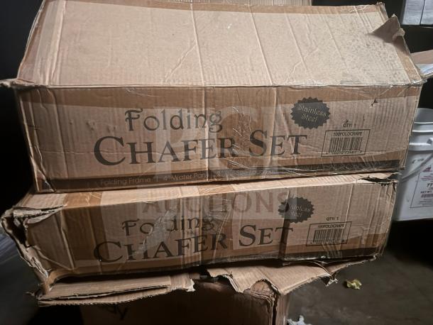 Two damaged boxes of full-size stainless steel chafer sets, labeled "Folding Chafer Set," with folding frame and 4" water pan.
