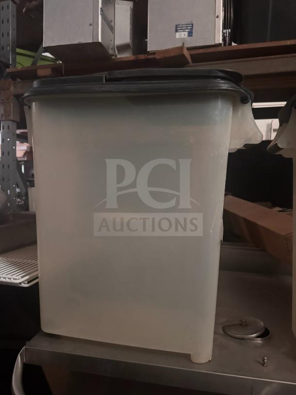 Translucent storage food container with a black lid, in good condition. Ideal for bulk storage. No visible labels.