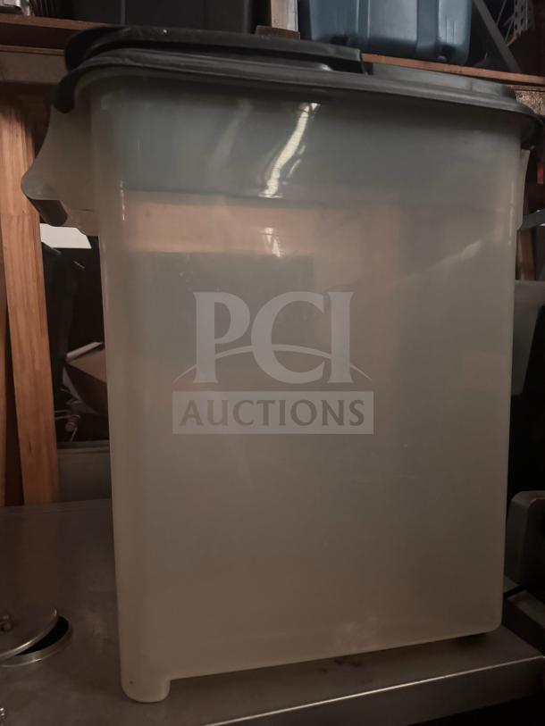 Translucent storage food container with black lid, rectangular shape, good condition, suitable for bulk storage.