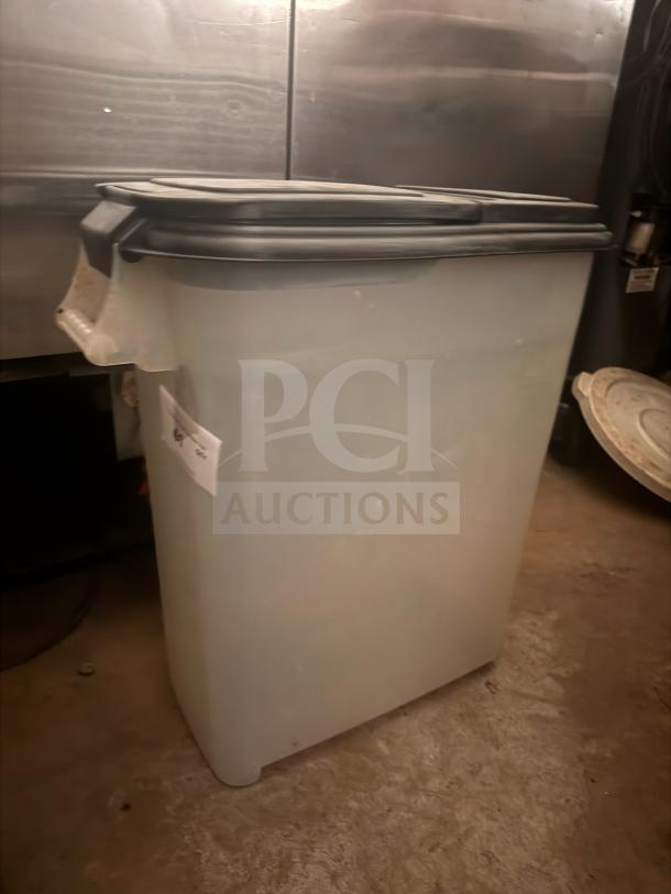 Large plastic storage food container with a black lid, labeled on the side. Used condition, suitable for bulk storage.