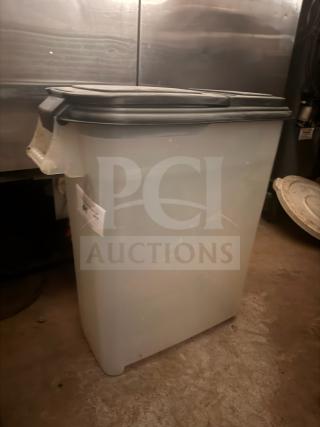 Large plastic storage food container with a black lid, labeled on the side. Used condition, suitable for bulk storage.