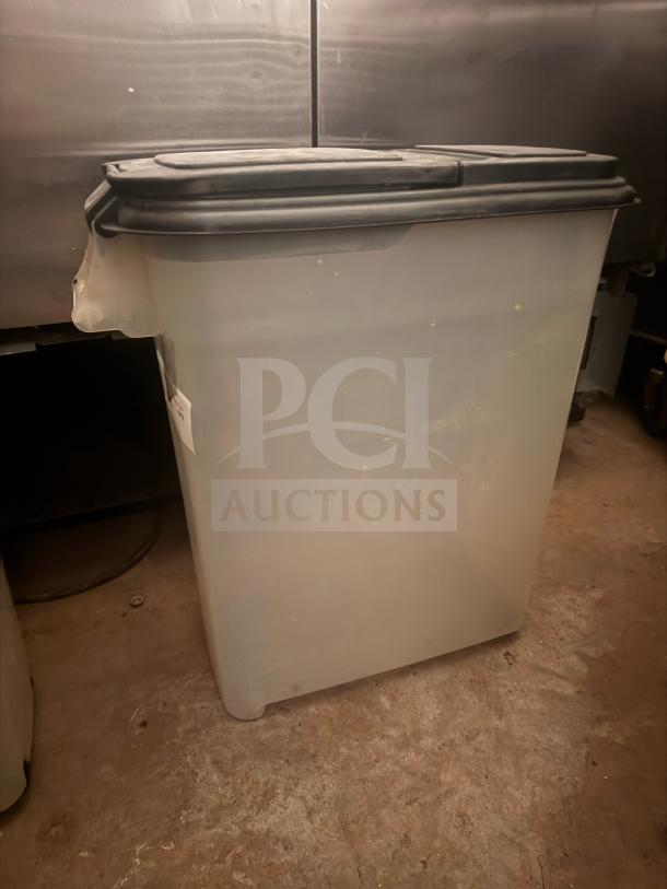 Large plastic storage food container with black lid, used condition, slight wear visible. Suitable for bulk storage.
