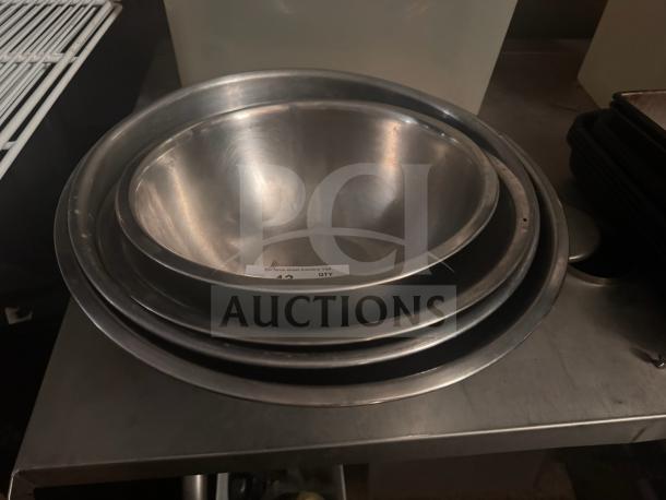 Stainless steel mixing bowl set in good condition, nested, polished finish, with a sticker indicating auction lot details.