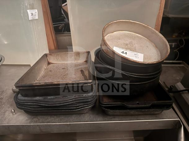 Lot of 17 miscellaneous baking pans, assorted shapes and sizes, visible wear, includes square and round pans, tagged for auction.