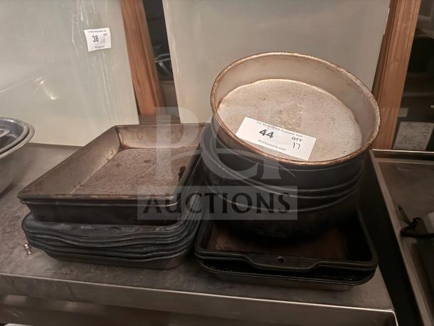 Lot of 17 miscellaneous baking pans, various shapes and sizes, used condition, auction tag visible.