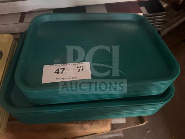 Green plastic food tray stack, rectangular, textured surface, label shows auction lot 47, quantity 24.