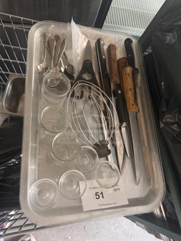 Miscellaneous kitchenware including knives, spoons, whisks, and glass jars on a tray. Auction lot 51.