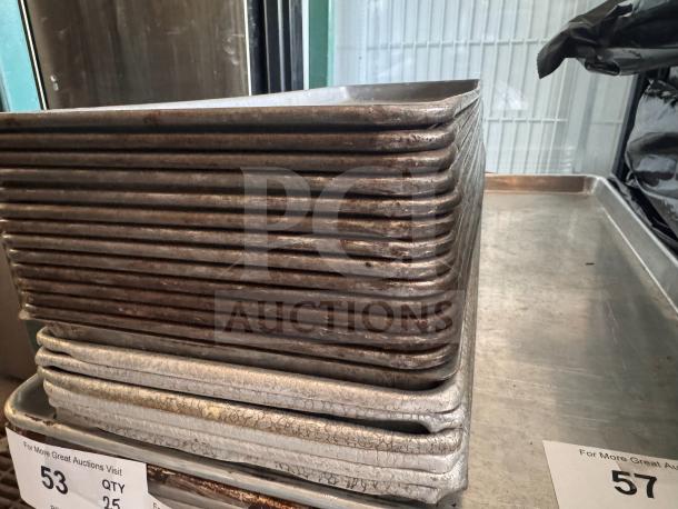 1/2 size long bakery display trays stacked. Used condition, metal finish, perfect for commercial bakery use. Auction tag visible.