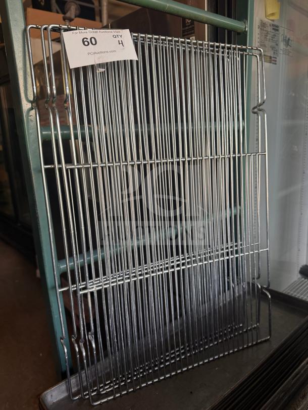 Metal cooling rack with grid pattern, gently used condition. Label indicates auction lot 60, quantity 4, via PCIAuctions.com.