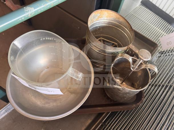 Miscellaneous kitchenware set with measuring jug, metal sifter, and press. Visible wear, priced all one money.