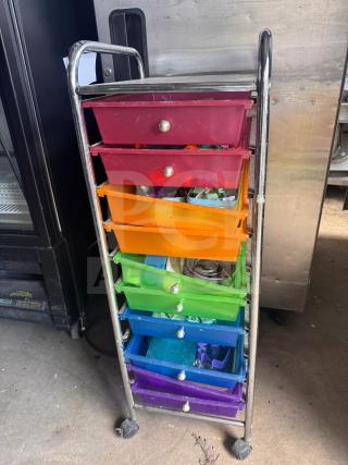 Colorful rolling storage cart with seven drawers, metal frame, and wheels. Drawers show various items inside. Good condition.