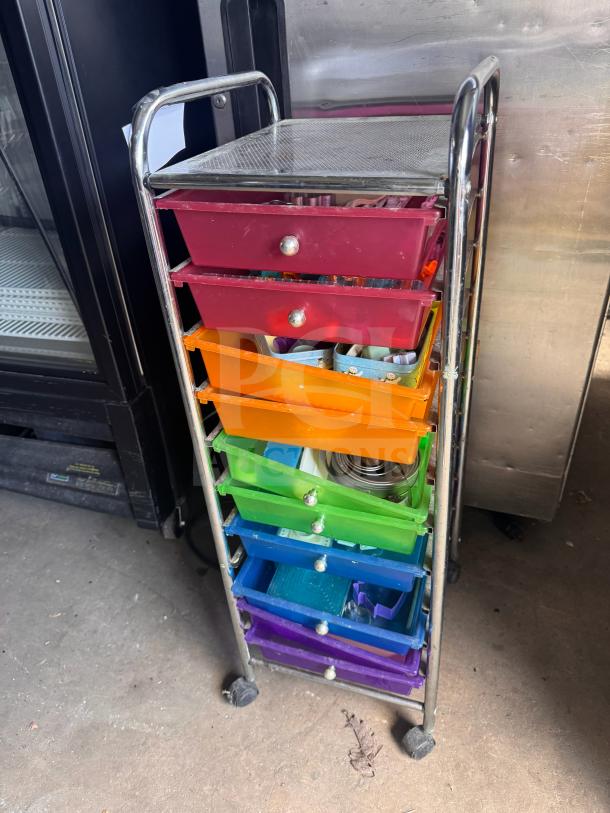 Colorful rolling storage cart with metal frame and six multicolored drawers, each with a knob. Appears in used condition.