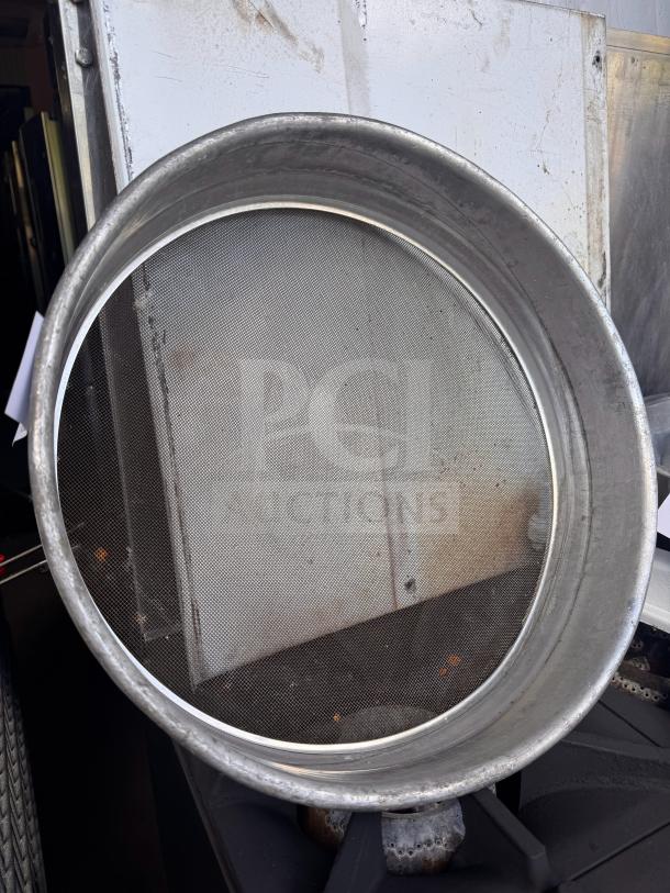 Aluminum flour sifter with wire mesh screen, in used condition, showing slight wear. No visible branding or labels.