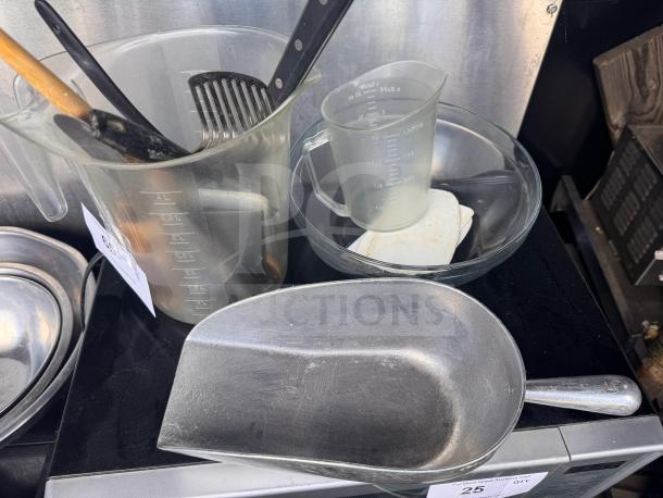 Mixed kitchenware lot includes plastic measuring cups, metal scoop, glass bowl, utensils. Used condition, sold together.