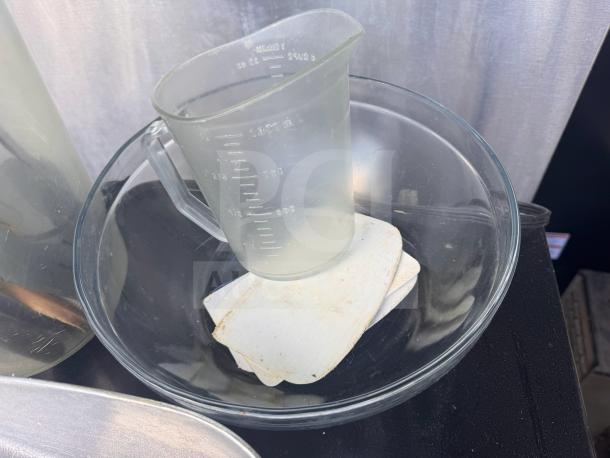Clear glass mixing bowl and measuring cup with white square coasters, slightly used condition.