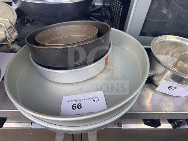Lot of 5 miscellaneous baking pans; various sizes, some wear, steel construction. Auction tag "66 QTY" visible.