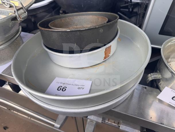 Lot of 5 assorted baking pans including round and rectangular shapes, various materials, visible wear and markings.