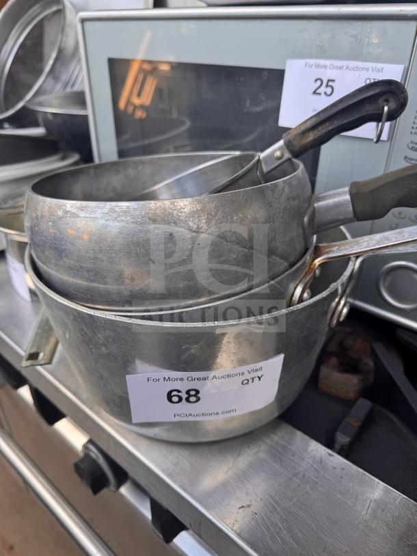 Metal saucepans with handles in used condition. Auction lot number 68 is visible.