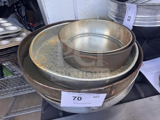 Lot of 5 assorted baking pans, used condition, various sizes and materials, some rust visible. Includes round and springform pans.