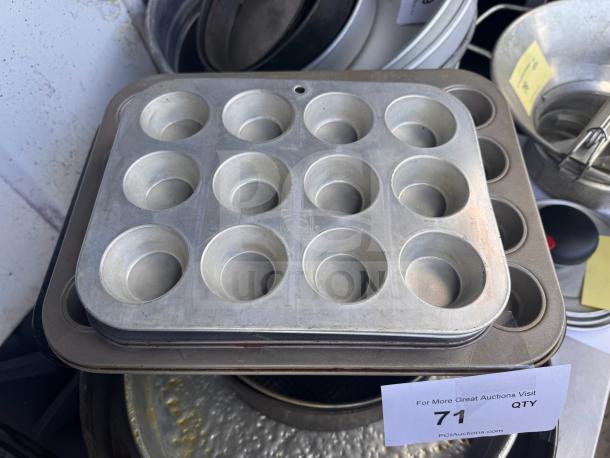 Aluminum muffin pan with 12 cups, slightly used, showing minor wear. Auction label with number 71 visible.