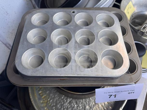 Aluminum muffin pan with 12 cups, visible auction label. Good condition, suitable for baking needs.