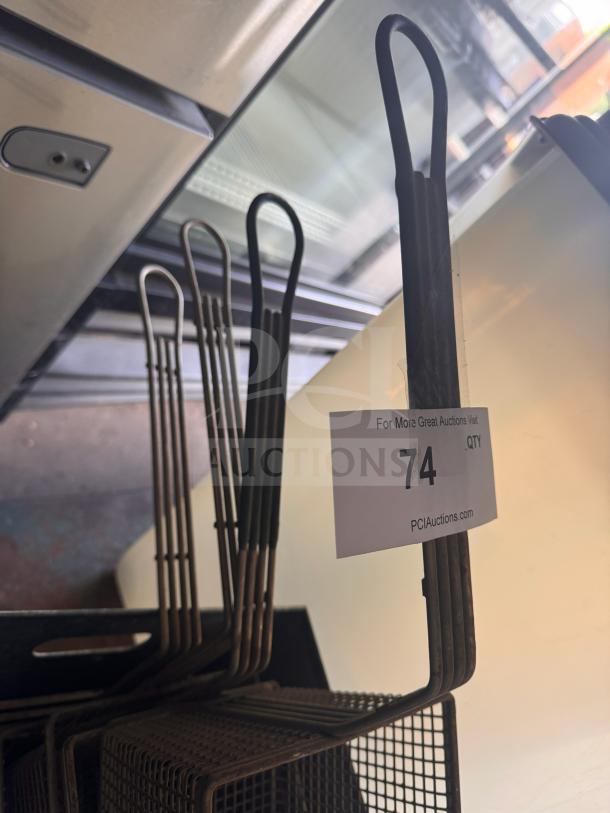 Metal fryer basket with long handle, multiple in set. Tag reads "74" from PCI Auctions. Appears in used condition.