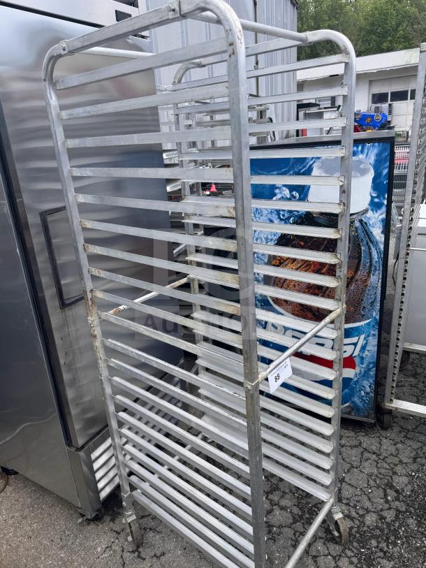 Metal sheet pan rack with multiple shelves, shows signs of wear. Includes a tag labeled "88". Ideal for commercial kitchens.