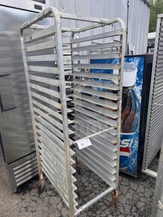 Industrial sheet pan rack with multiple slots, metal construction, visible wear and rust, wheels for mobility. Tag labeled "89."