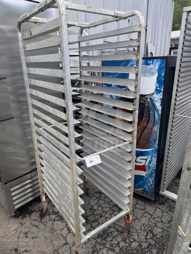 Metal sheet pan rack with 20 slots, four caster wheels, visible wear and rust. Auction tag indicates lot number 89.